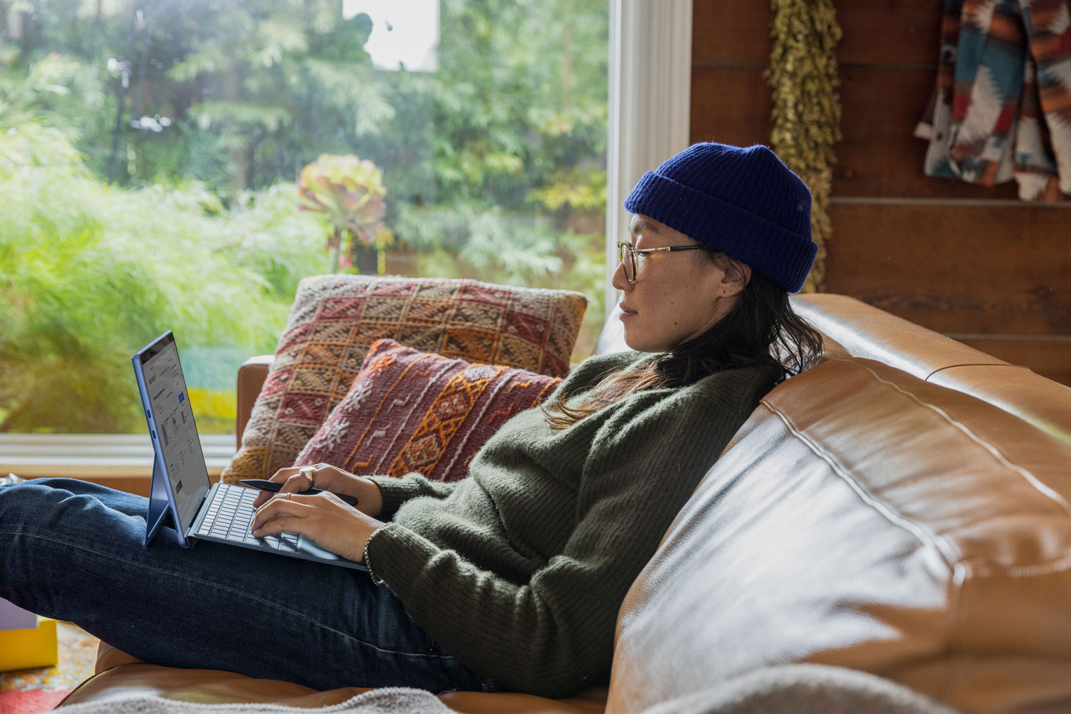 A person sat on the couch with a laptop