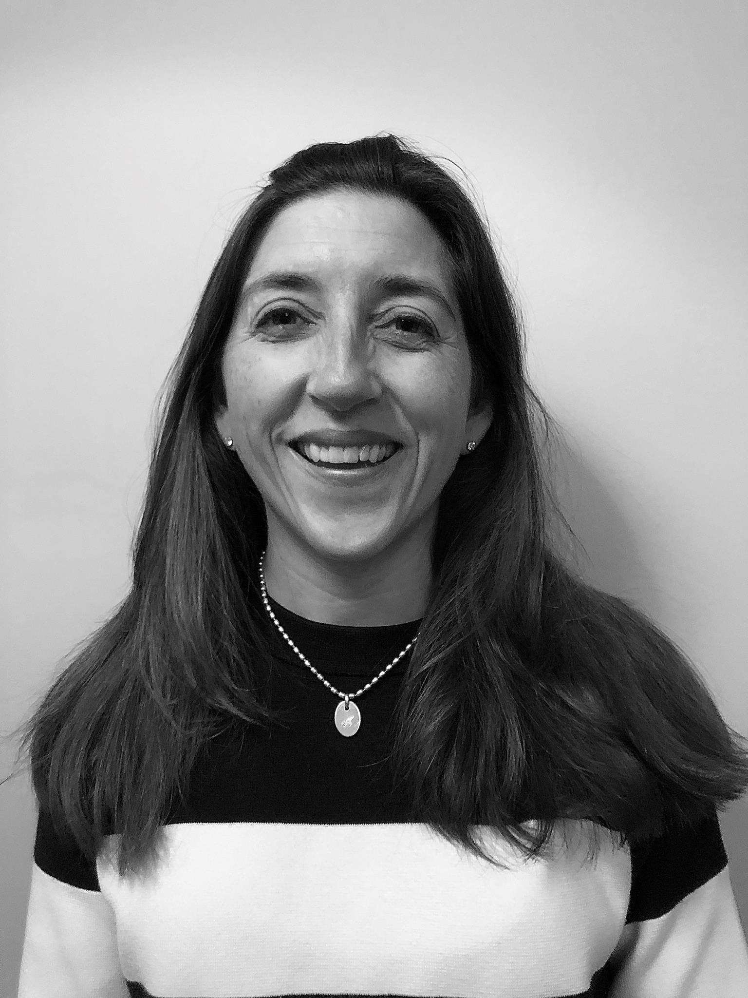 A black and white photo of Prof Martin. She is smiling and is stood against a white wall