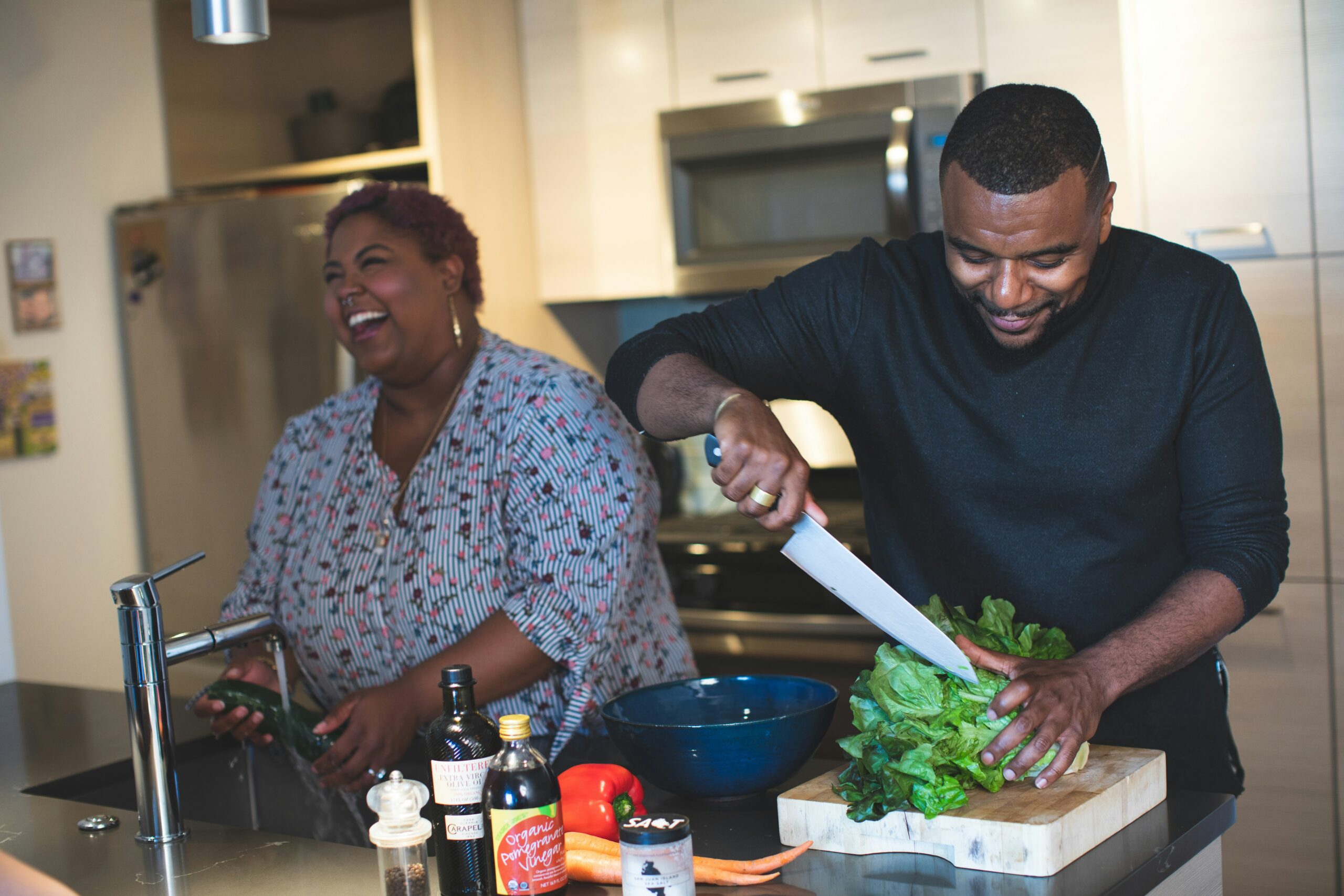 A young couple preparing food in the kitchen