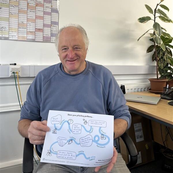 A man smiling holding a filled in pathway