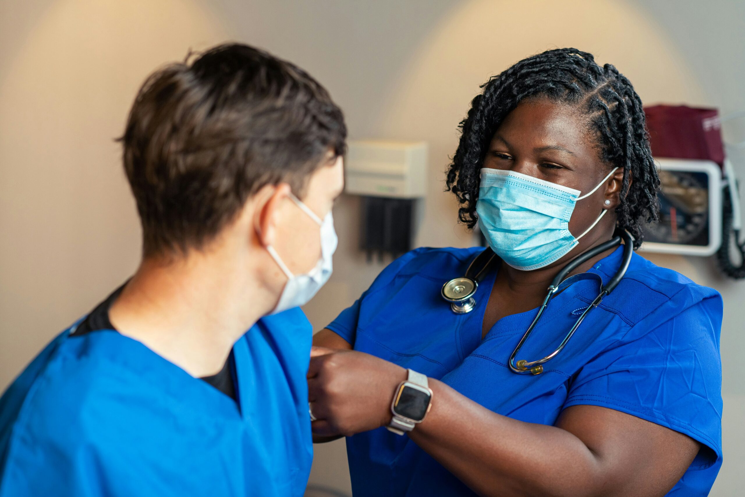 A nurse administers a vaccine to another nurse.