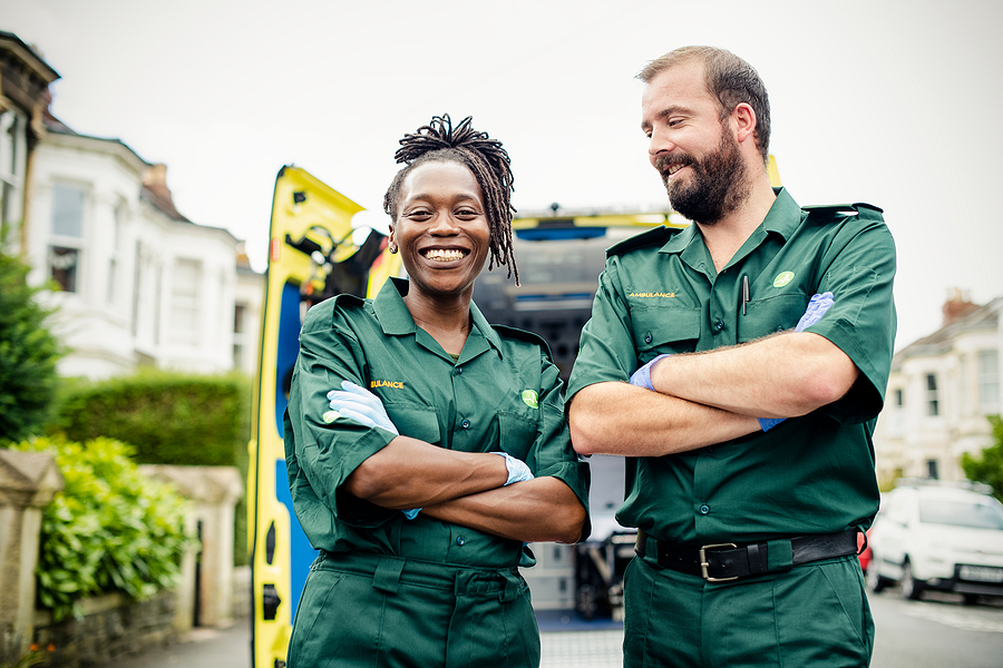 Two ambuance workers stood in front of an ambulance