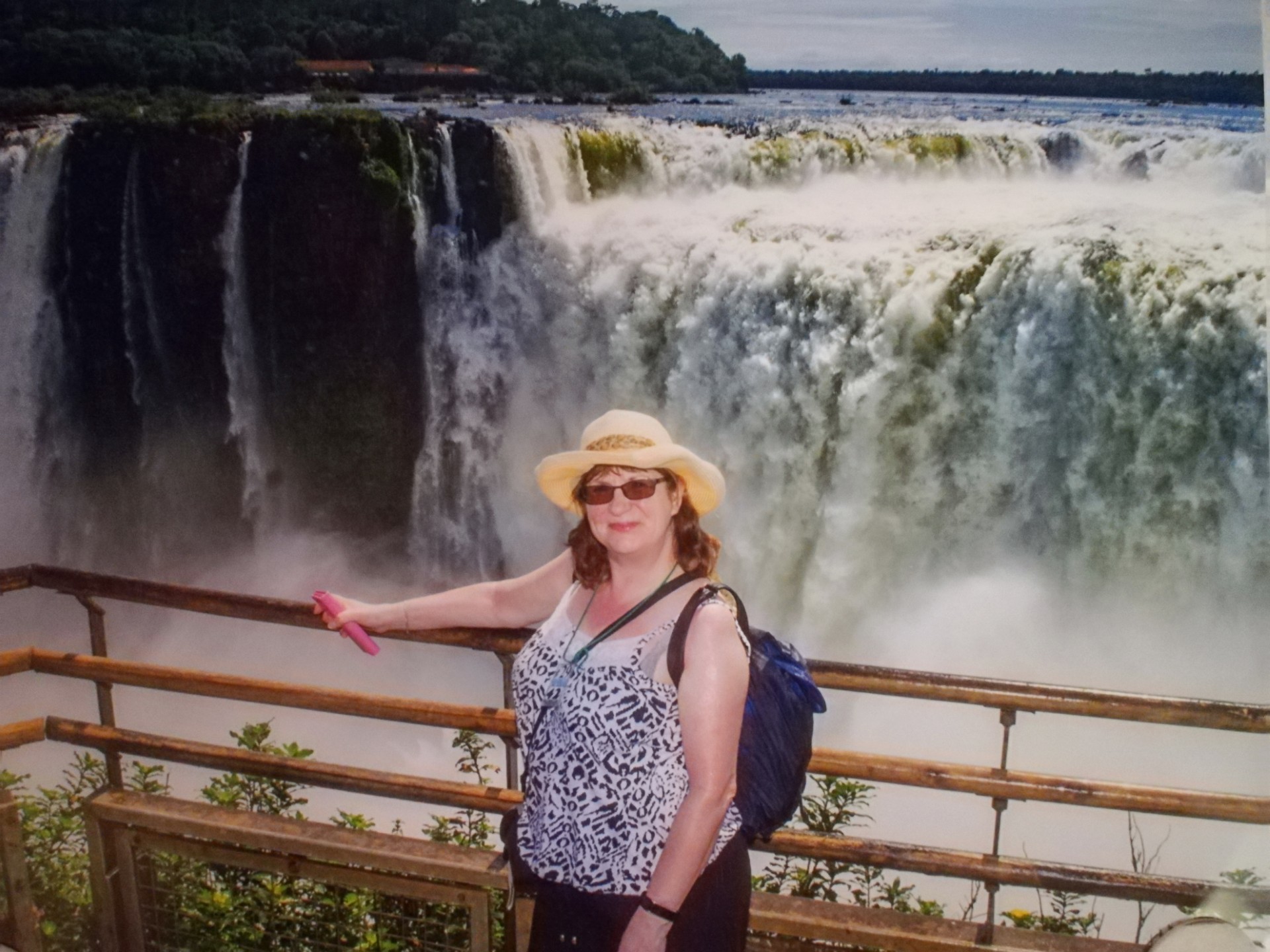 A woman stood in front of a large waterfall
