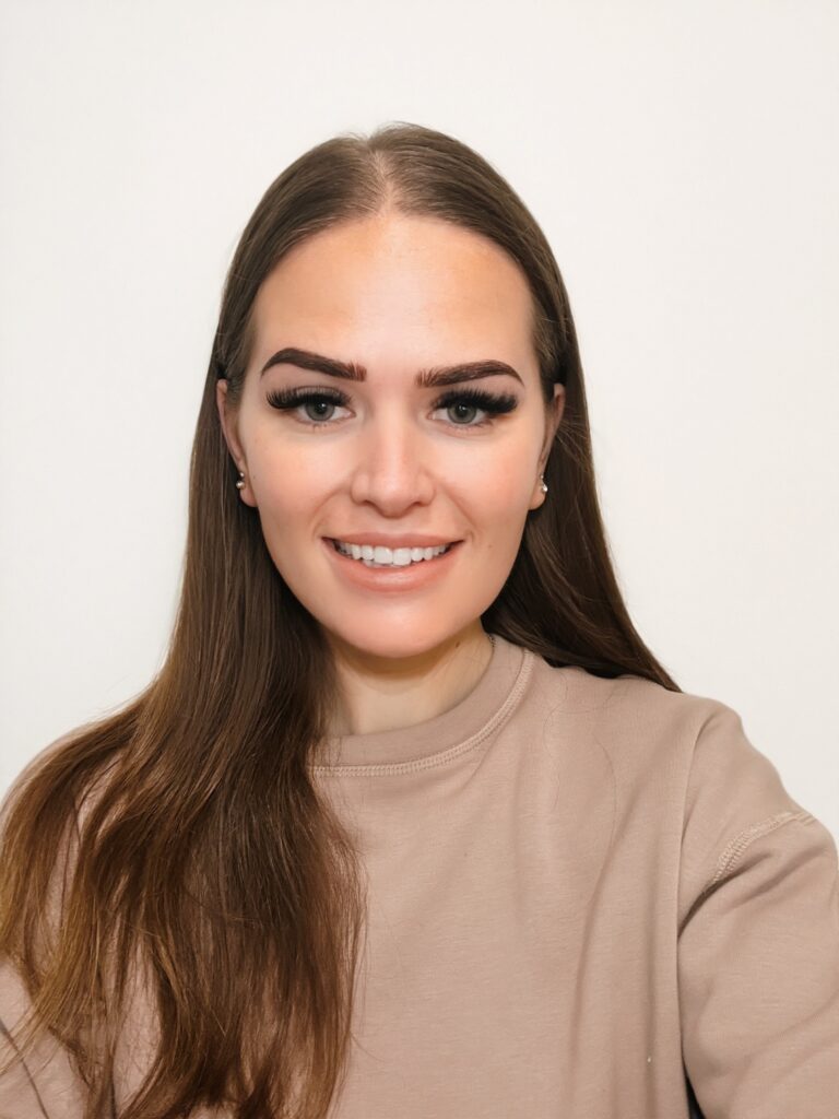 A young woman with dark hair stood against a white background