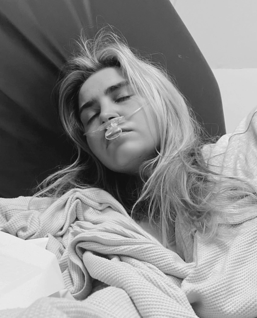 Tilly Rose lying down with her eyes shut, wearing a nasal cannula 