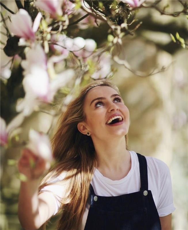 Tilly Rose smiling under a tree with pink flowers