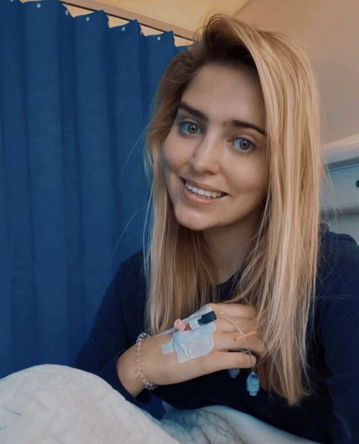Tilly smiling with an IV on her hand