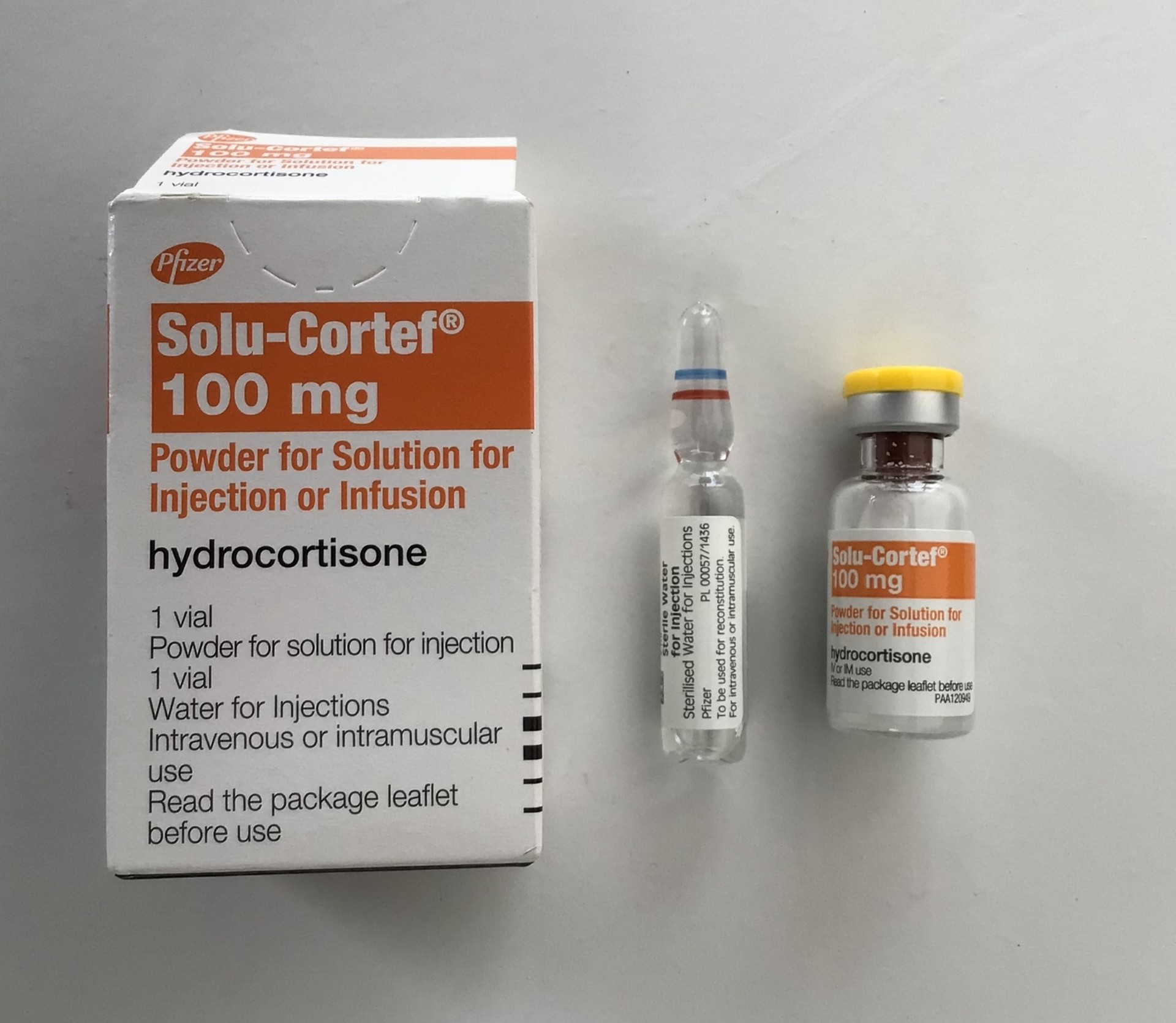 a jar of powdered hydrocoirtisone, the cardboard box it comes in and the vial of water it comes with