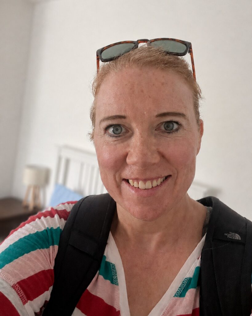 Helen smiling wearing a backpack inside.